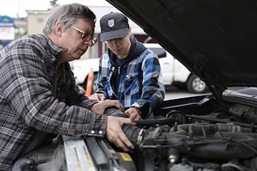 Father teaching son how to work on a car